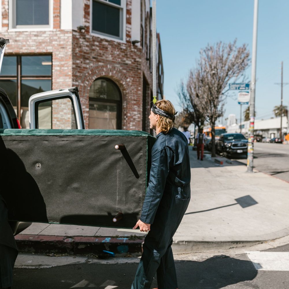 Worker loading items onto a pickup truck on a city street