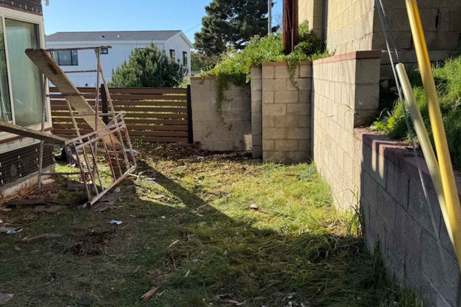 Backyard with broken wood and yard debris before cleanup